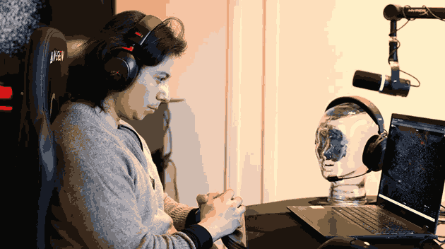 Ramses Alcaide wearing over-ear headphones while concentrating on a laptop computer screen.